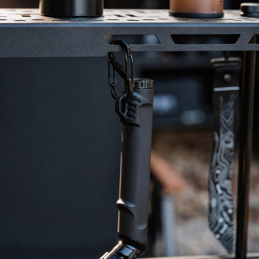 Black outdoor ignition tool attached to an outdoor gear setup
