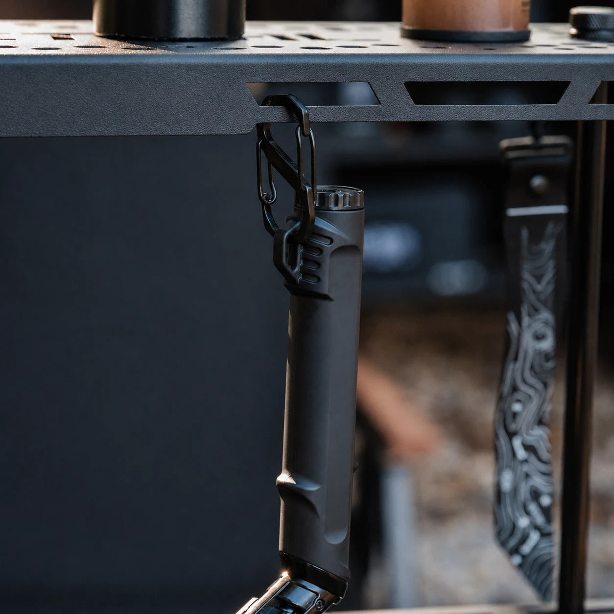 Black outdoor ignition tool attached to an outdoor gear setup